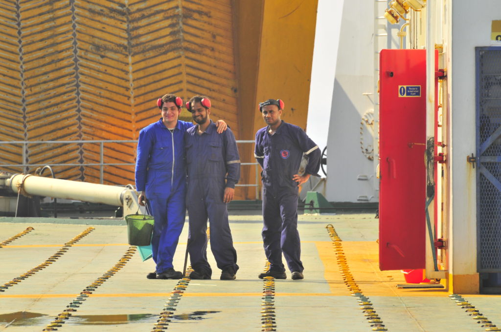 Trois marins sur le pont d'un bateau