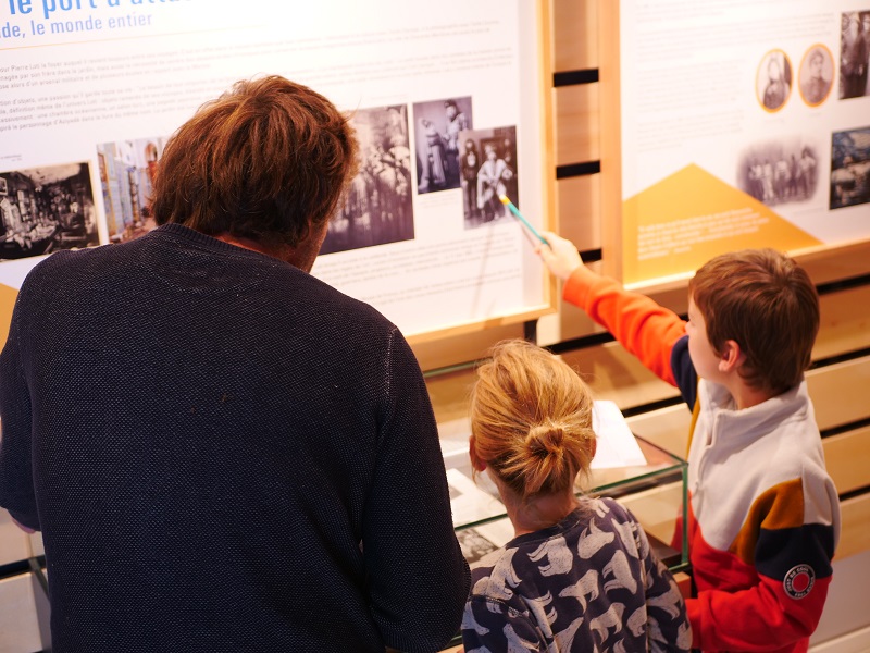 Une famille visite l'exposition "Pierre Loti, un marin au tournant du siècle".