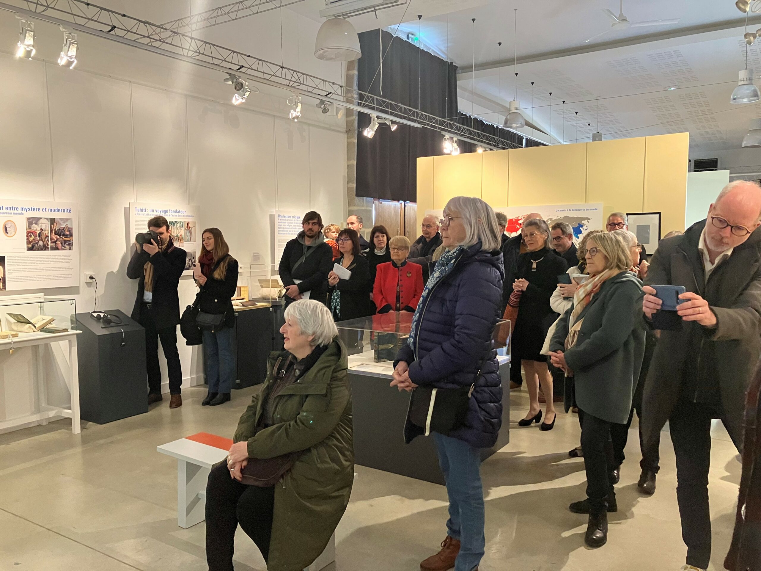 Un groupe écoute un discours dans un espace d'exposition.