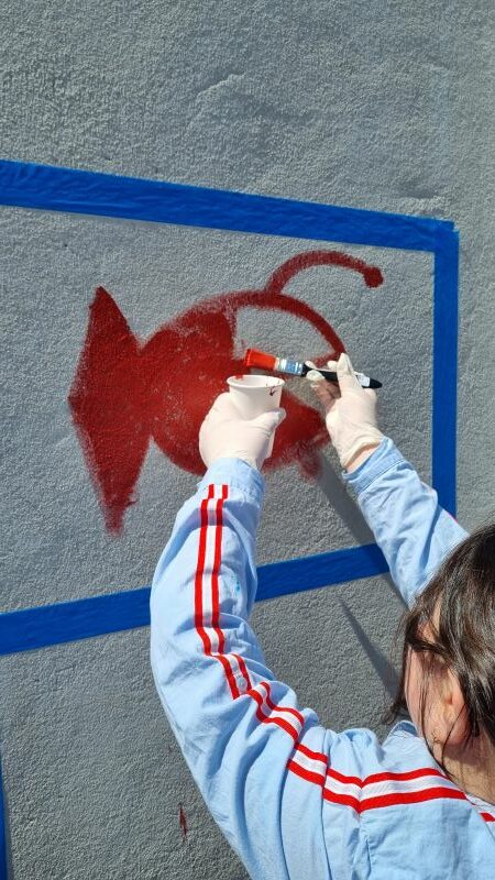 Les élèves s'entrainent à peindre au mur.